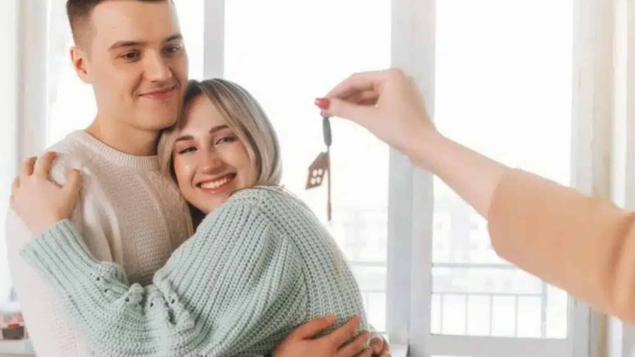 A happy couple given a key to their new home.